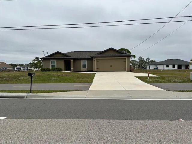 View of front of house with a front lawn and a garage