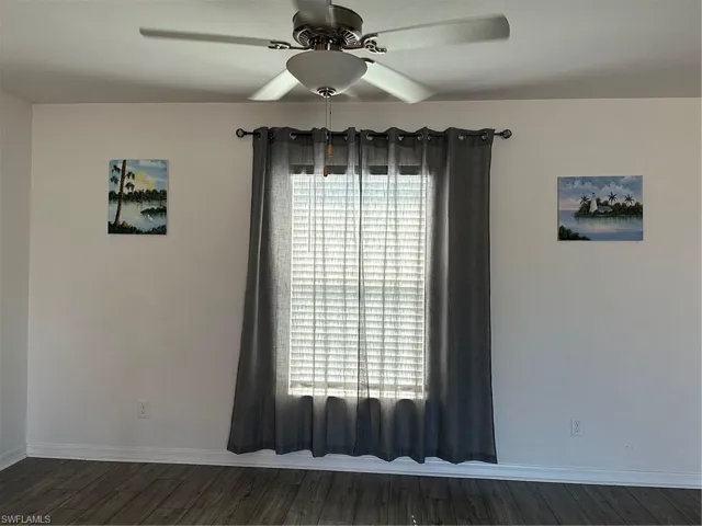 Spare room featuring ceiling fan and dark hardwood / wood-style flooring