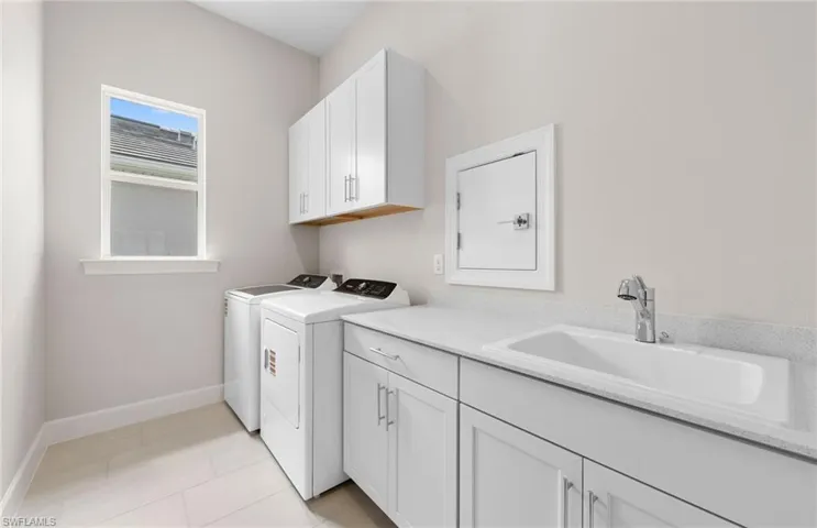 Clothes washing area featuring cabinet space, washing machine and dryer