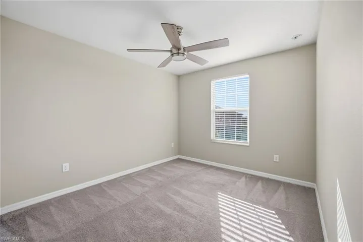 Spare room featuring carpet flooring and ceiling fan