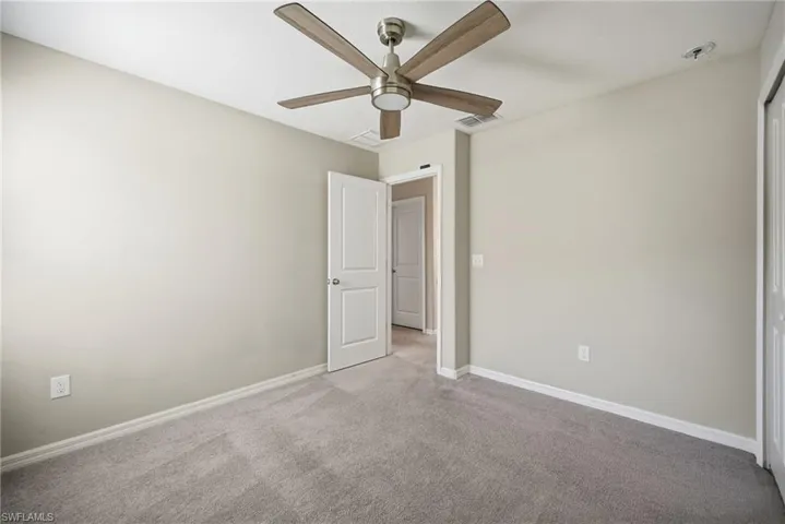 Unfurnished bedroom with carpet, a ceiling fan, and a closet