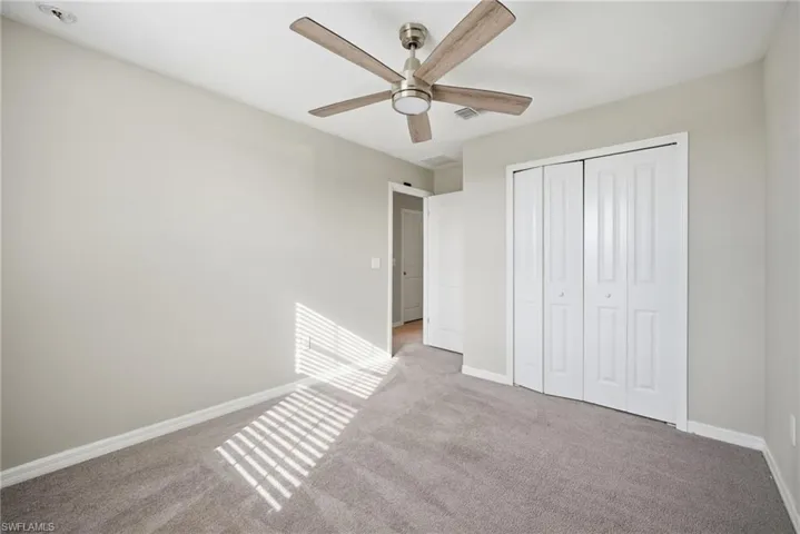 Unfurnished bedroom featuring carpet, a closet, and ceiling fan