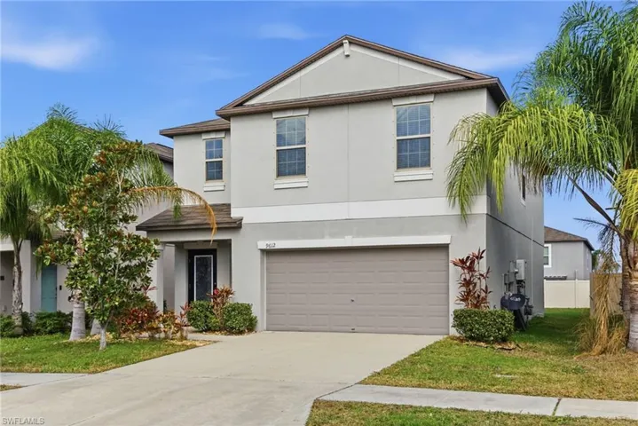 View of front of house featuring stucco siding, a front lawn, driveway, and an attached garage