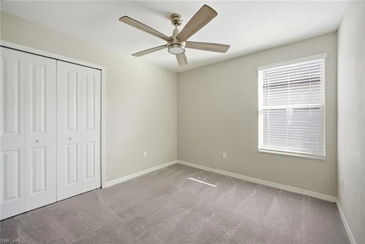Unfurnished bedroom featuring carpet, a closet, and a ceiling fan