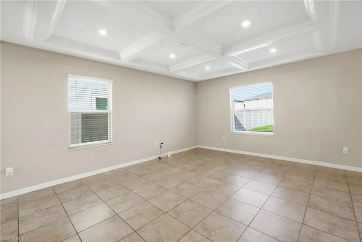 Spare room with recessed lighting, coffered ceiling, light tile patterned floors, and crown molding