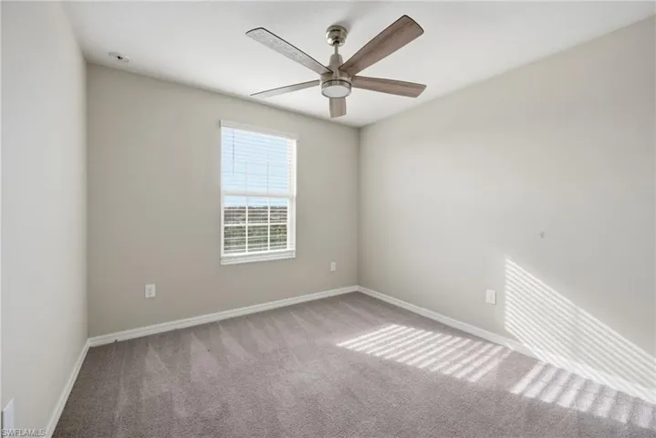 Carpeted empty room with baseboards and ceiling fan