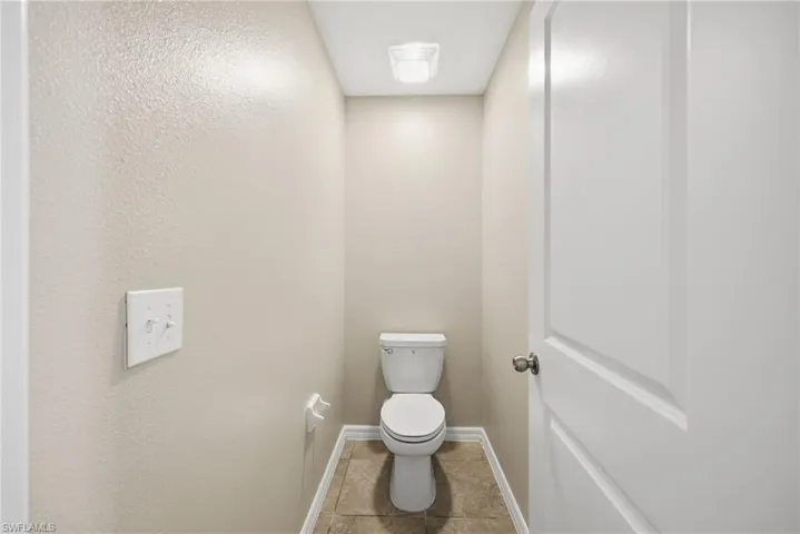 Bathroom with toilet and light tile patterned floors