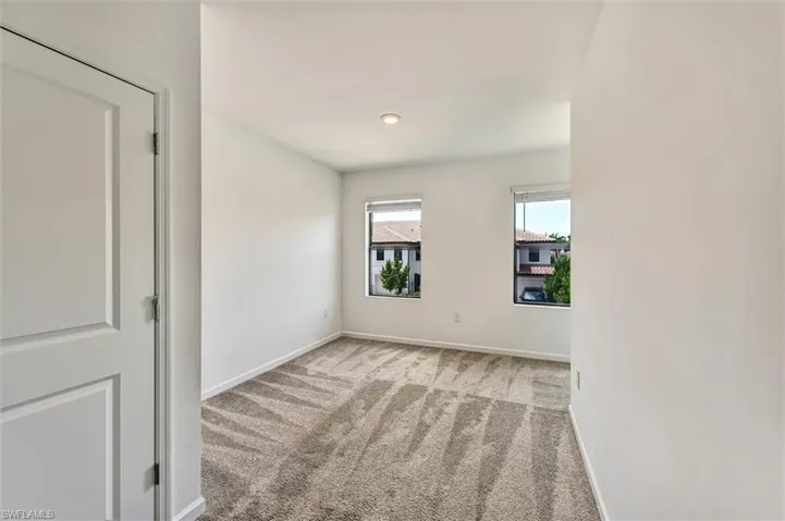 Bright and spacious bedroom featuring large windows, wood-look flooring, and a clean modern aesthetic — a peaceful retreat within this stunning Lake Jessup home.