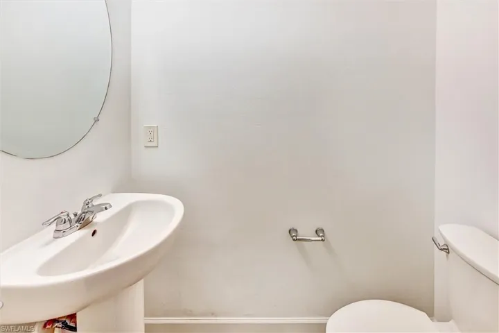 Convenient first-floor half bathroom with a pedestal sink, updated fixtures, and tasteful finishes — ideal for guests and everyday use on the main living level.