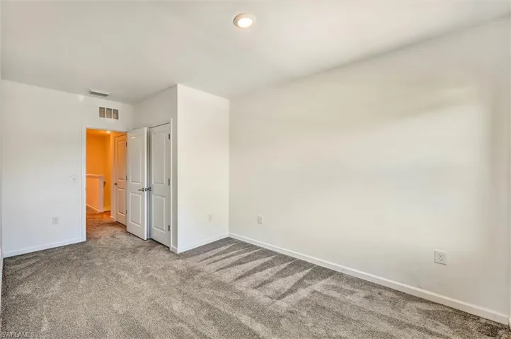 Generously sized bedroom with wood-look flooring and large windows providing abundant natural light, offering a warm and inviting atmosphere throughout.