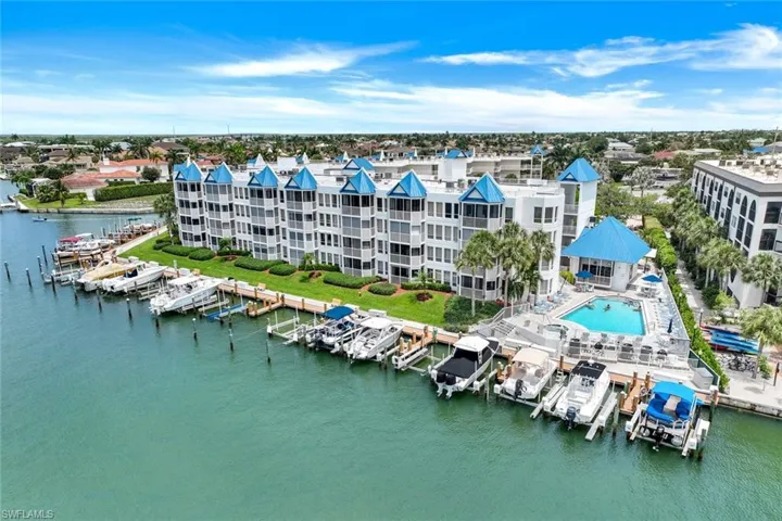 Drone / aerial view of numerous boat docks and a nearby body of water