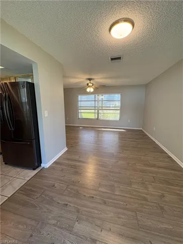 Unfurnished room with hardwood / wood-style floors and a textured ceiling