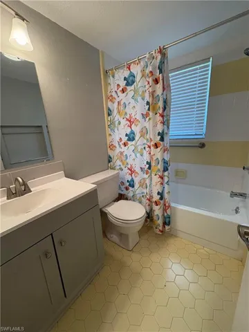 Full bathroom with shower / tub combo, tile patterned floors, vanity, and toilet