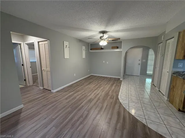 Unfurnished room with ceiling fan, a textured ceiling, and light hardwood / wood-style flooring