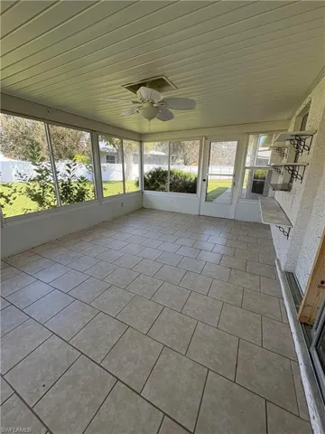 Unfurnished sunroom with ceiling fan