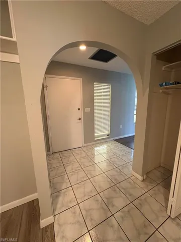 Foyer with a textured ceiling and light tile patterned floors