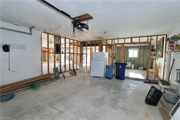 Garage with freestanding refrigerator and a garage door opener
