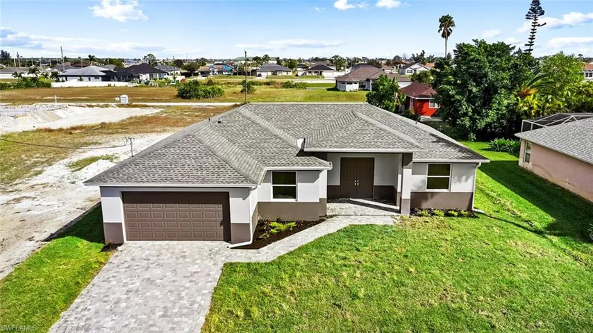 View of front of house with a garage and a front yard