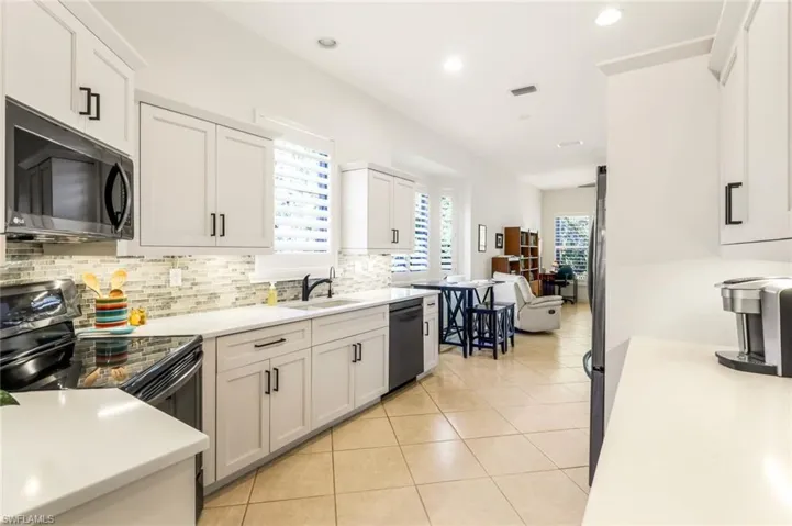 Newly updated kitchen with quartz counters, white cabinetry and stainless steel appliances.
