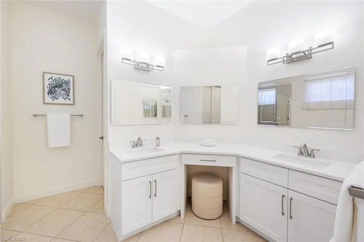 Primary in-suite bath with updated cabinetry, counters, lighting and fixtures.