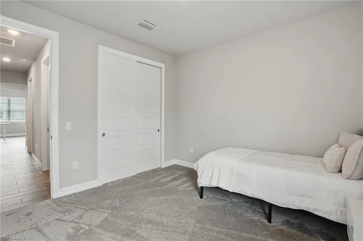 Carpeted bedroom with baseboards, a closet, and recessed lighting
