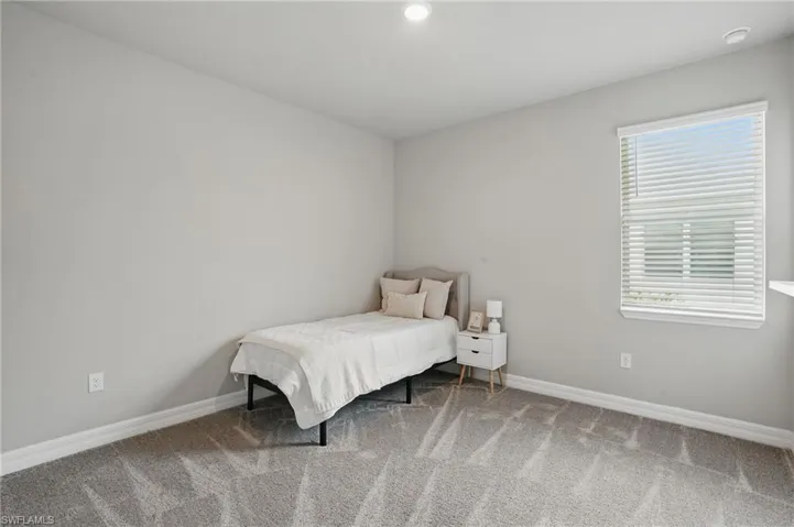 Carpeted bedroom featuring baseboards, multiple windows, and recessed lighting