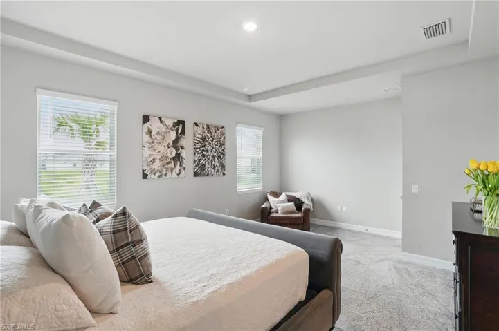 Bedroom featuring light colored carpet, baseboards, multiple windows, and recessed lighting