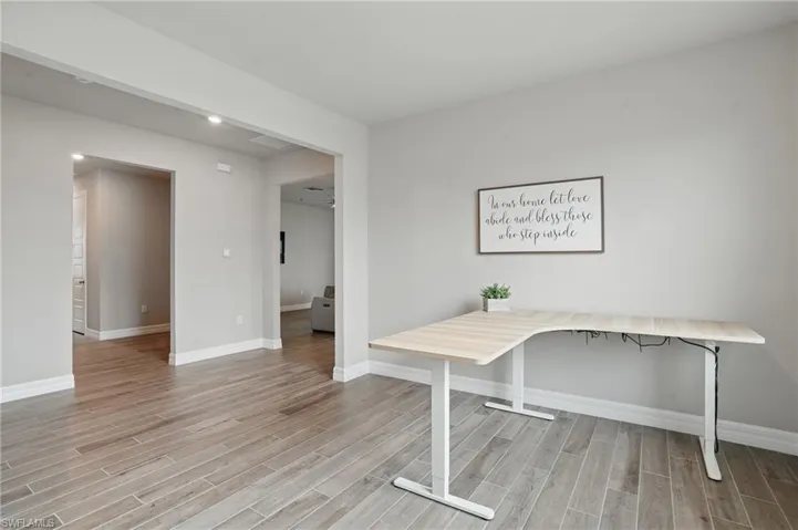 Unfurnished office featuring light wood finished floors, baseboards, and recessed lighting