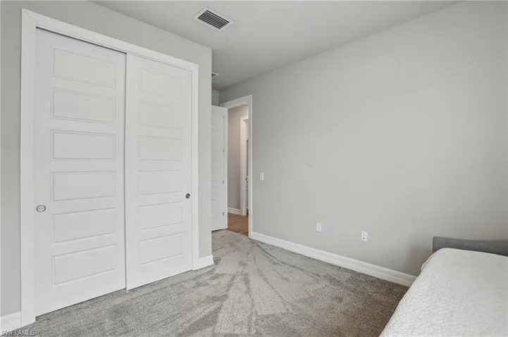 Bedroom featuring carpet flooring, a closet, and baseboards