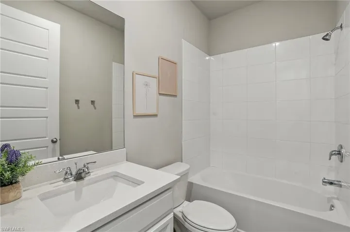 Full bathroom featuring toilet, vanity, and shower / tub combination