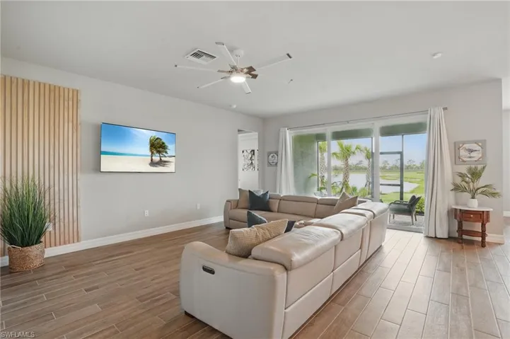 Living room with wood finished floors, baseboards, and a ceiling fan