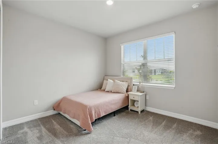Bedroom featuring carpet floors and baseboards