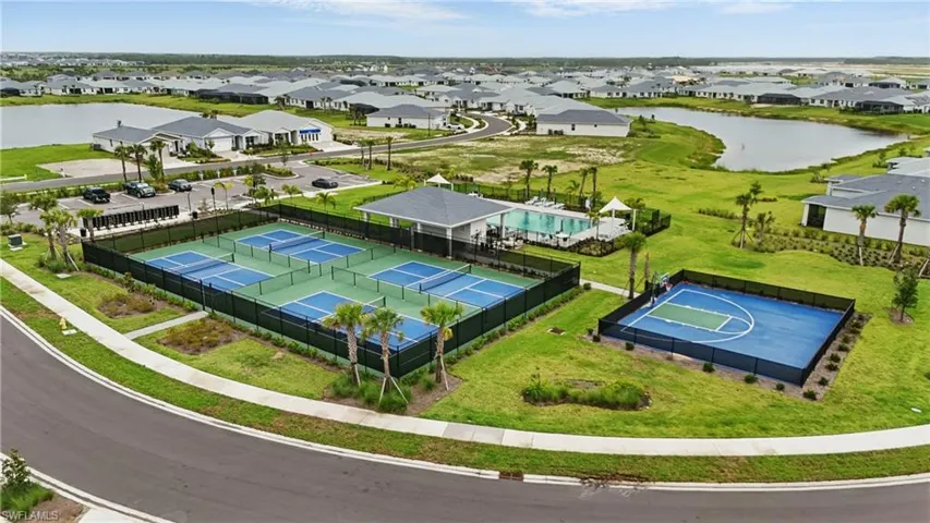Aerial perspective of suburban area featuring a large body of water and a pool area