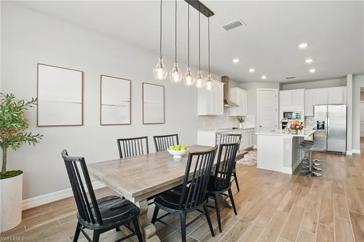 Dining space with light wood-type flooring, baseboards, and recessed lighting