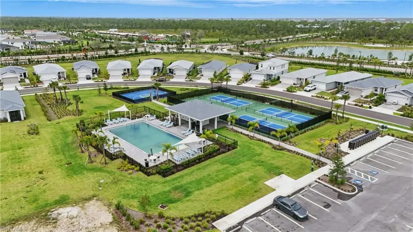 Aerial view of residential area featuring a nearby body of water and a pool