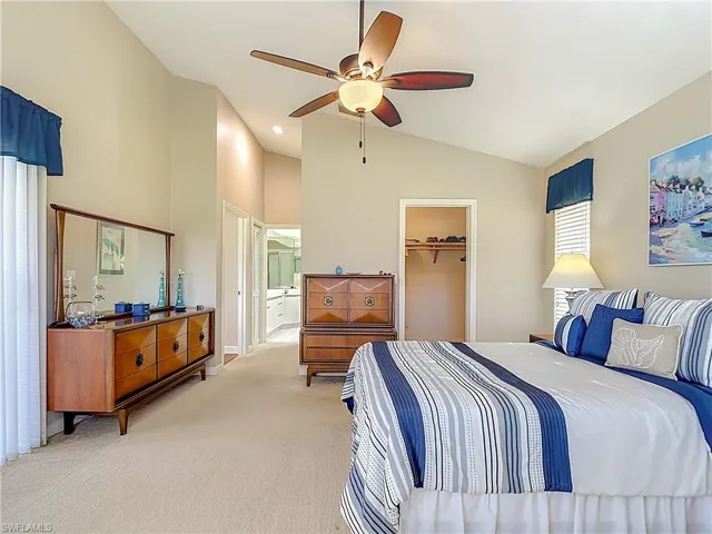 Primary Bedroom featuring vaulted ceiling, carpet floors, a ceiling fan, a walk in closet, and recessed lighting