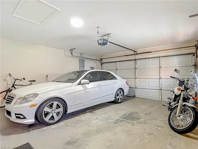 Garage featuring electric panel and a garage door opener