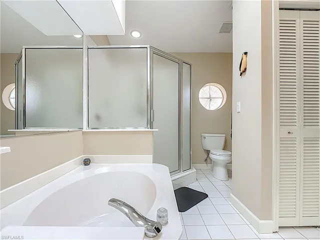Full bathroom with a closet, light tile patterned floors, a stall shower, a bath, and recessed lighting