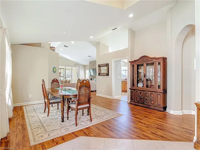 Dining area with laminate floors, lofted ceiling, and recessed lighting
