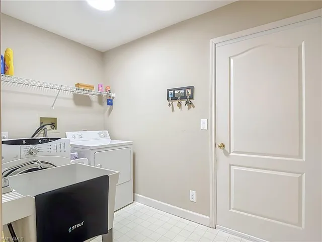 Laundry area featuring a utility tub  and washing machine and clothes dryer