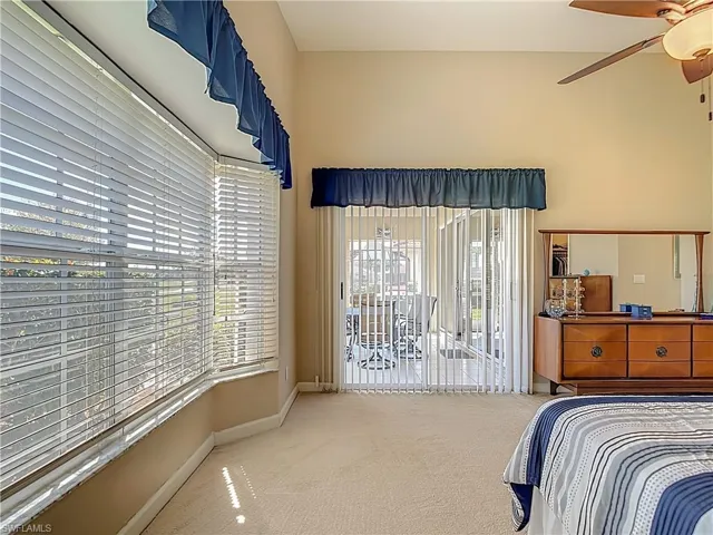 Primary Bedroom featuring carpet flooring, access to exterior, and ceiling fan