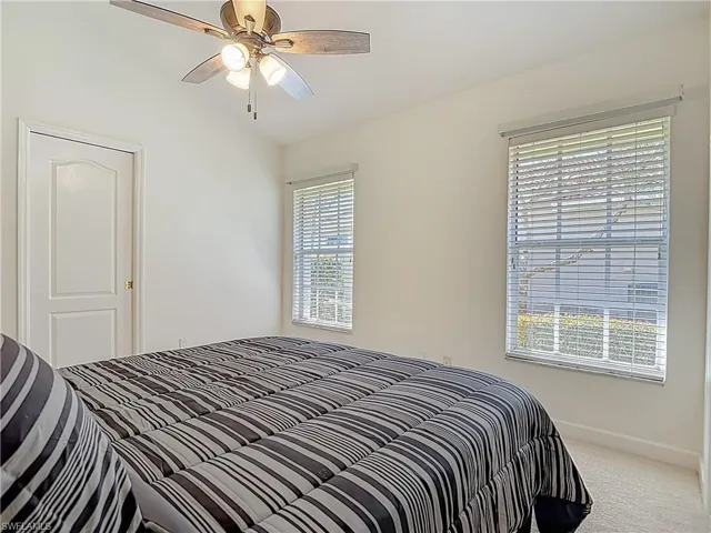 Bedroom featuring carpet flooring, lofted ceiling, and ceiling fan
