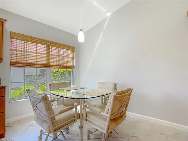 Eat in Kitchen with light tile patterned floors and vaulted ceiling
