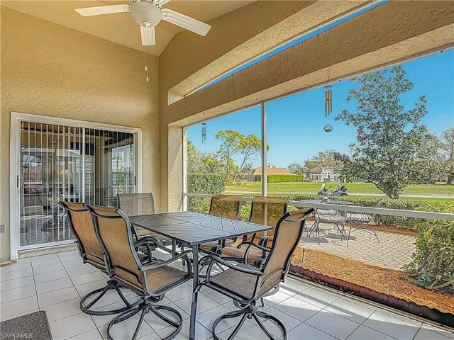 Screened in lanai featuring a patio, outdoor dining space, and a ceiling fan