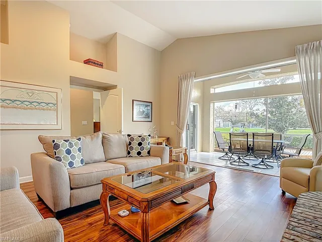 Living area with laminate floors and lofted ceiling
