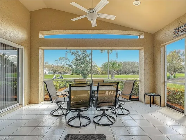 Screened in lanai, lofted ceiling, tile patterned flooring, golf course view, and healthy amount of natural light