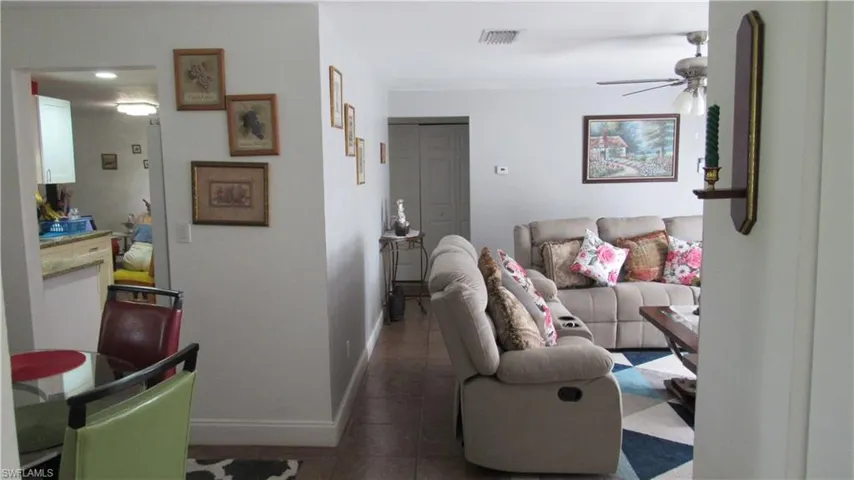Living room featuring ceiling fan and tile patterned flooring