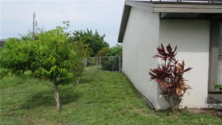 View of property exterior featuring stucco siding and a gate
