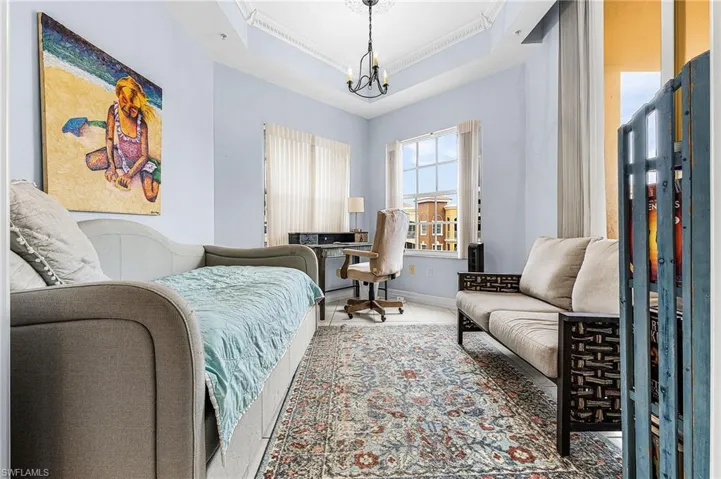 Tiled bedroom with a tray ceiling, a chandelier, and ornamental molding