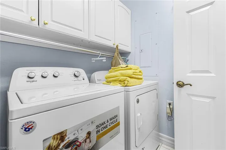 Washroom featuring cabinet space, washer and dryer, and electric panel